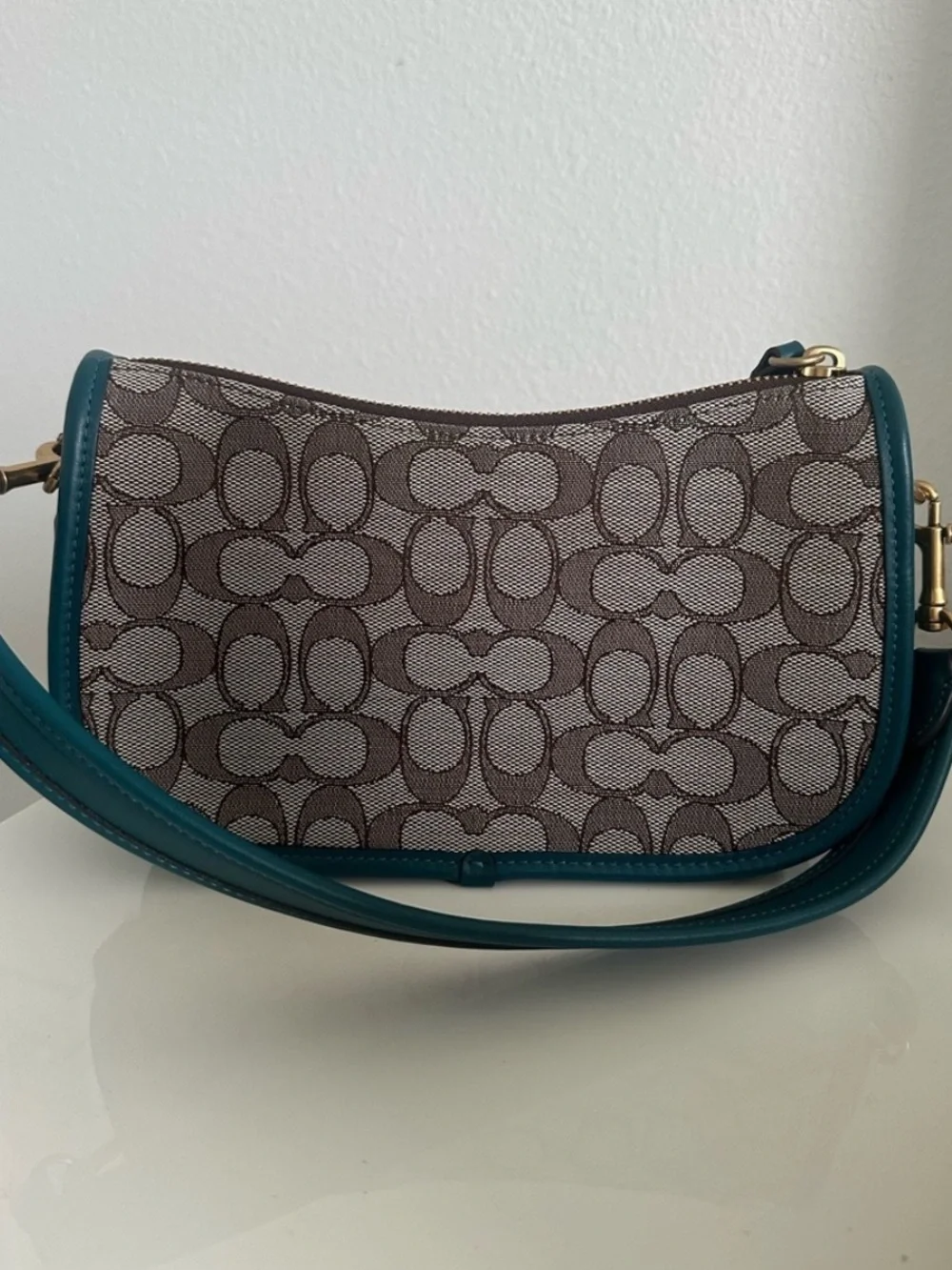 Coach Swinger in Sinature jacquard Teal soft leather and  brownSignature-Pattern